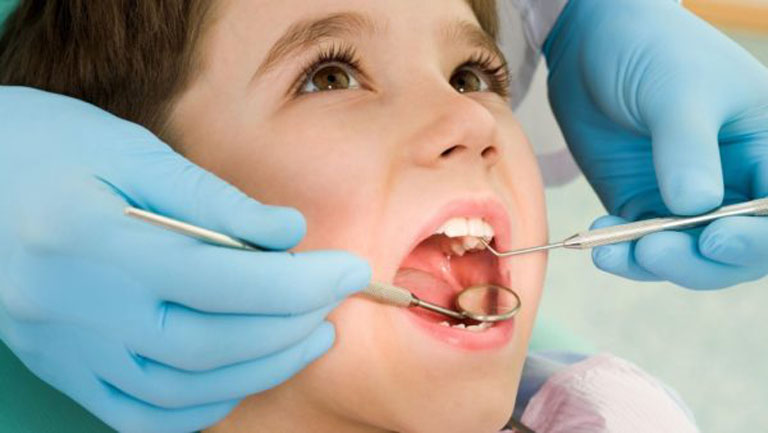 Đưa trẻ đến gặp bác sĩ thăm khám tiến hành điều trị sâu răng bằng phương pháp chuyên khoa